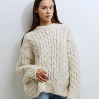 Kvinde i off-white striktroeje kigger mod kameraet