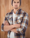 Mand i hvid t-shirt og topbestiger letvaegts skjorte og graa beanie