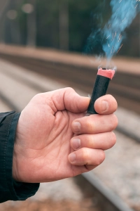 Mand holder braendende baalstartssaet med flint i haanden