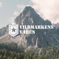 vildmarkens vaaben logo foran et stort bjerg